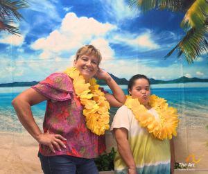 Two ladies posing together in front of beach backdrop