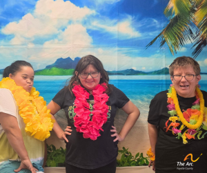 three women posing in front of beach backdrop