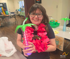 A smiling Adult Taining Facility (ATF) participant holding a cup.