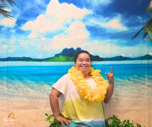 Girl smiling and posing in front of a beach backdrop