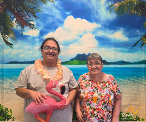 Man and woman posing in front of beach backdrop